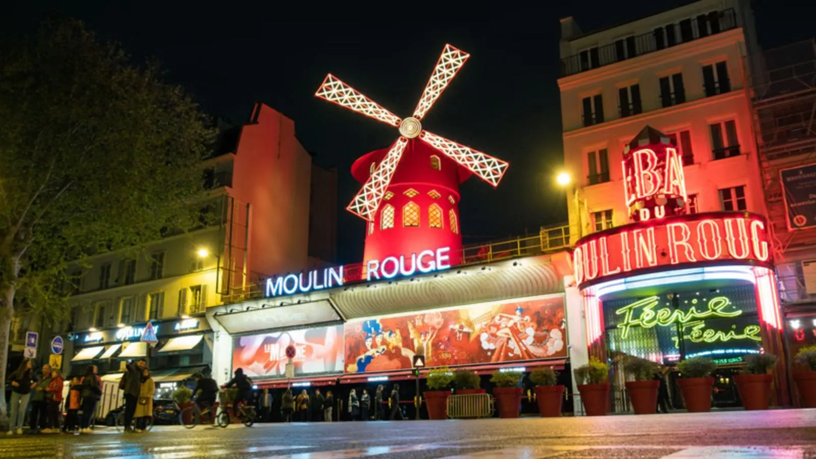 Moulin Rouge iluminado de noche en el barrio de Montmartre en París
